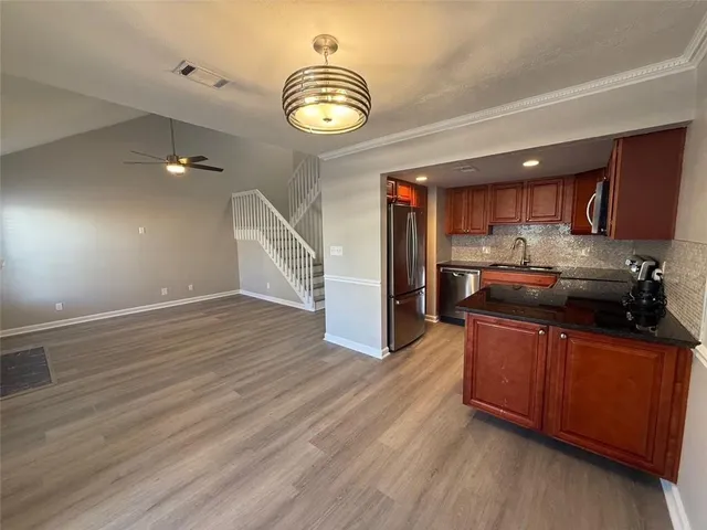 a kitchen with stainless steel appliances granite countertop a refrigerator and a sink