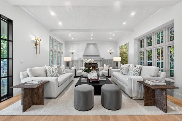 a living room with furniture a large window and a fireplace