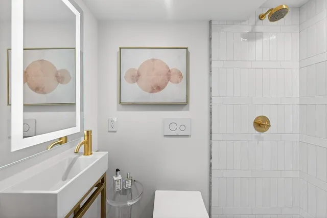 a bathroom with a sink mirror vanity and toilet