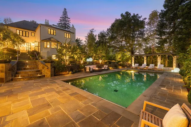 a view of swimming pool with outdoor seating and a tree