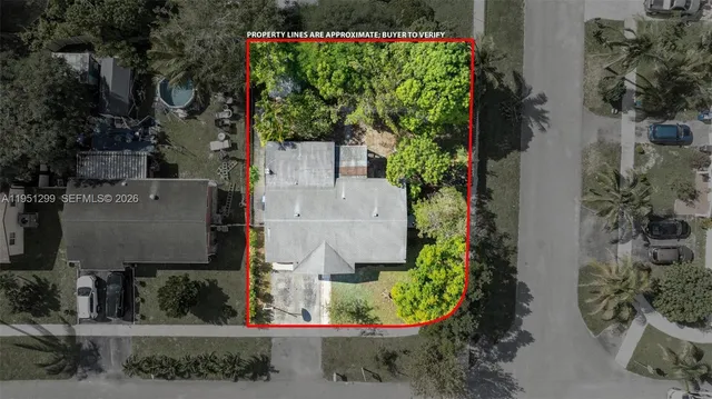 an aerial view of residential houses with outdoor space and trees