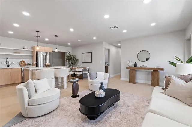 a living room with furniture and a view of kitchen