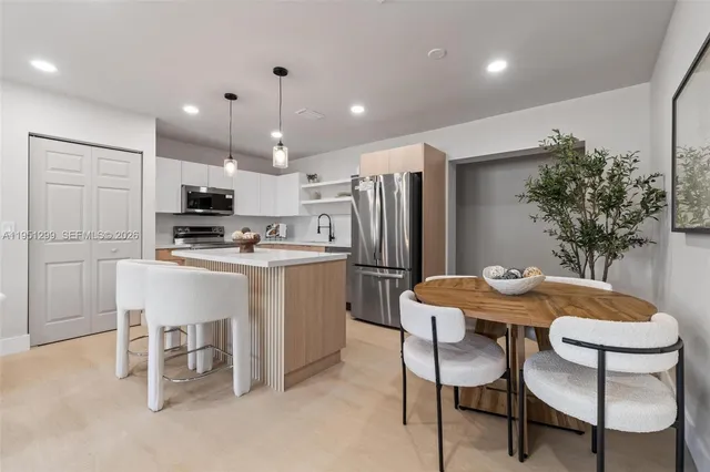 a kitchen with kitchen island a refrigerator stove microwave and cabinets
