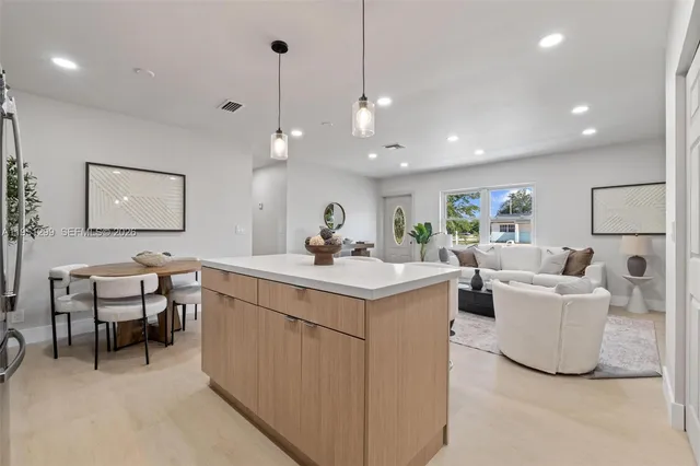 a kitchen with kitchen island a table and chairs in it