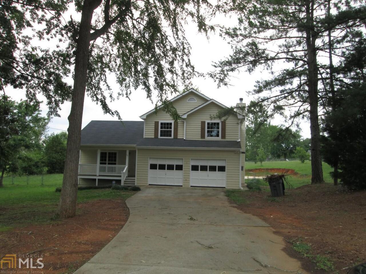 145 Cedar Ridge Road Locust Grove, GA 30248 - Photo 1 of 1 a view of a white house with a large tree and a yard in front of it