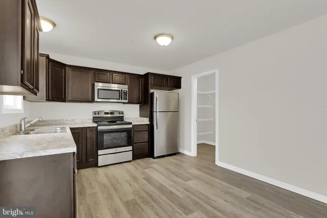 a kitchen with granite countertop a refrigerator stove and sink