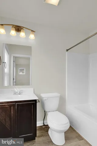 a bathroom with a sink a toilet a mirror and vanity