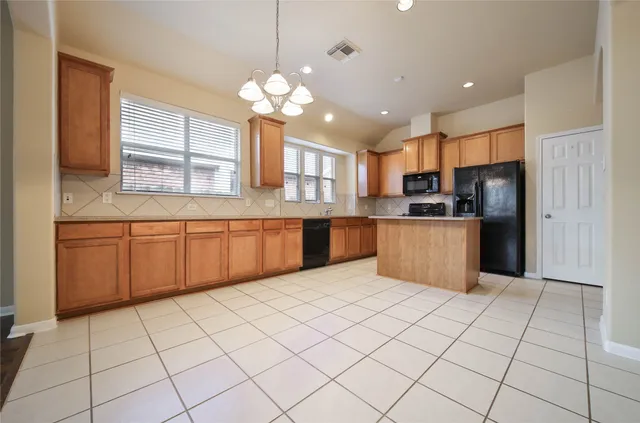 a large kitchen with stainless steel appliances granite countertop a sink dishwasher stove top oven and cabinets