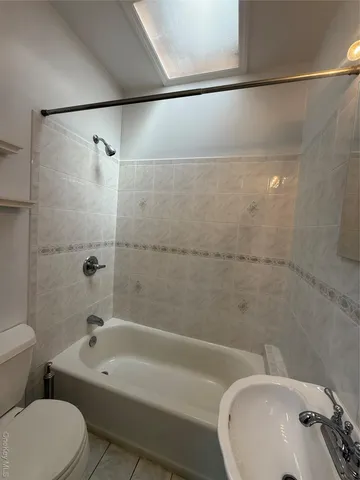 a bathroom with a white bath tub a sink and a toilet