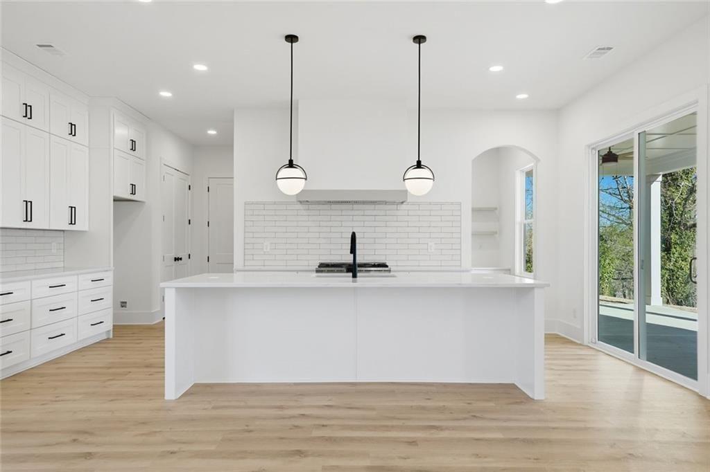 253 Northridge Road Ball Ground, GA 30107 - Photo 17 of 37 a large kitchen with stainless steel appliances kitchen island a large island in the center and wooden floor