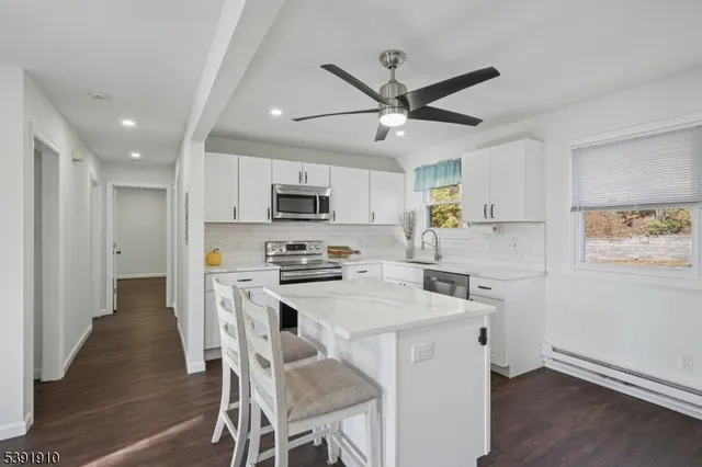 a kitchen with stainless steel appliances a stove a sink island and a refrigerator