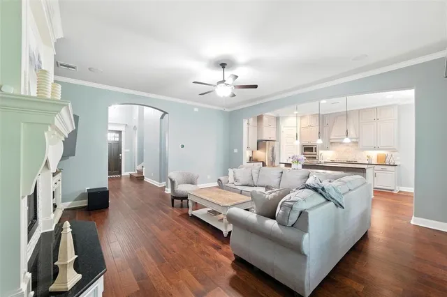 a living room with furniture kitchen view and a wooden floor