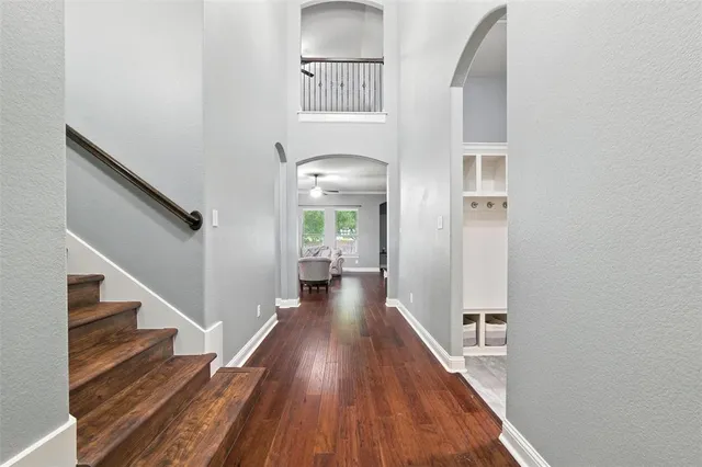 a view of a hallway with wooden floor and staircase