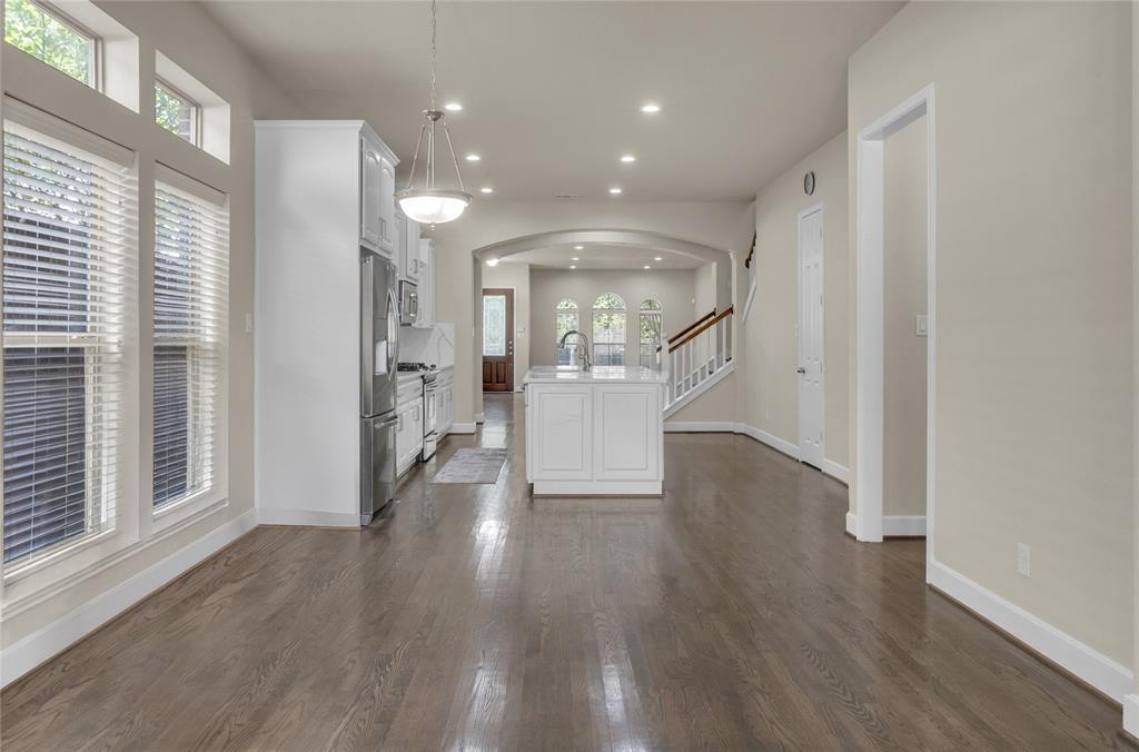 2407 Knight Street Dallas, TX 75219 - Photo 9 of 24 a view of an empty room with wooden floor and a window