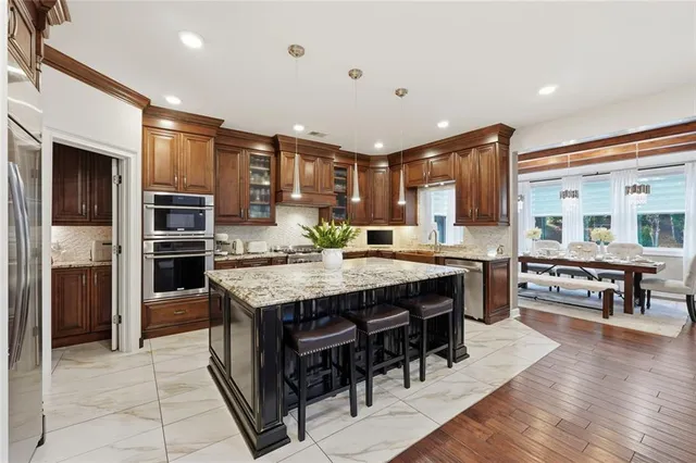 a large kitchen with stainless steel appliances granite countertop a stove and cabinets