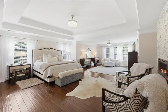 a spacious bedroom with a bed and wooden floor