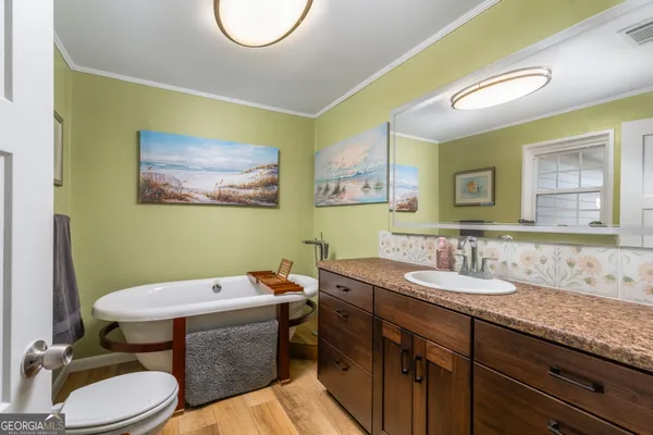 a bathroom with a granite countertop sink mirror and toilet