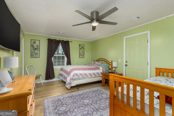 a bedroom with a bed a chandelier and a dresser