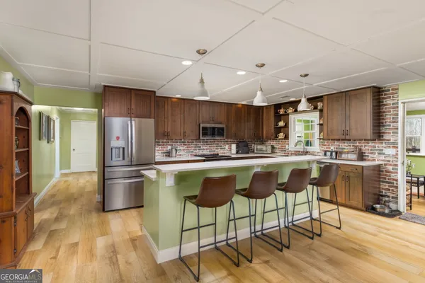 a kitchen with stainless steel appliances granite countertop a refrigerator a stove top oven and a sink