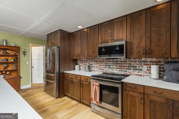 a kitchen with stainless steel appliances wooden cabinets and a stove top oven