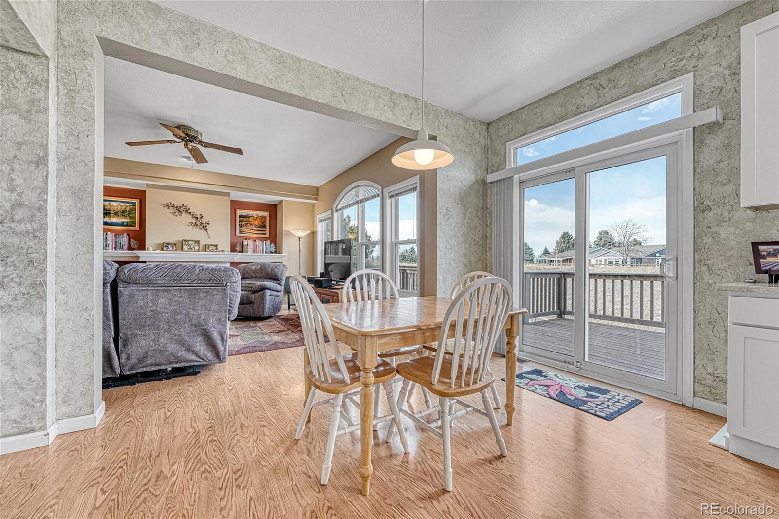 9247 Sugarstone Circle Highlands Ranch, CO 80130 - Photo 13 of 48 a dining room with furniture a chandelier and wooden floor