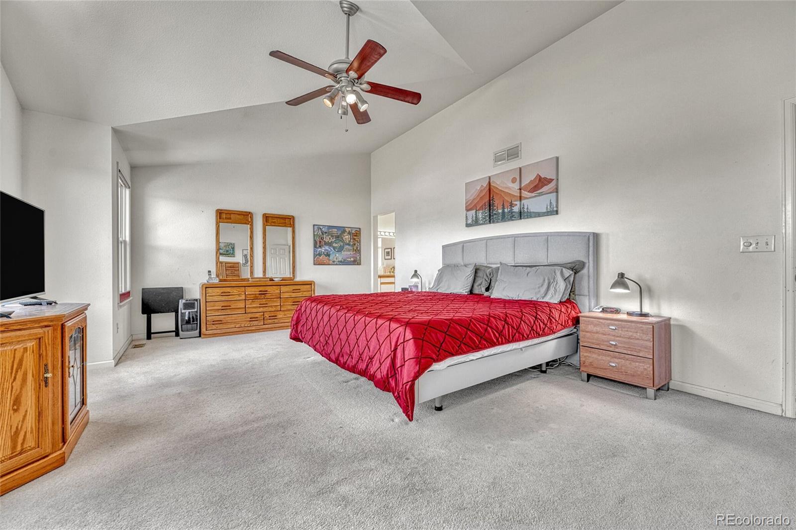 9247 Sugarstone Circle Highlands Ranch, CO 80130 - Photo 18 of 48 a spacious bedroom with a bed and a flat screen tv