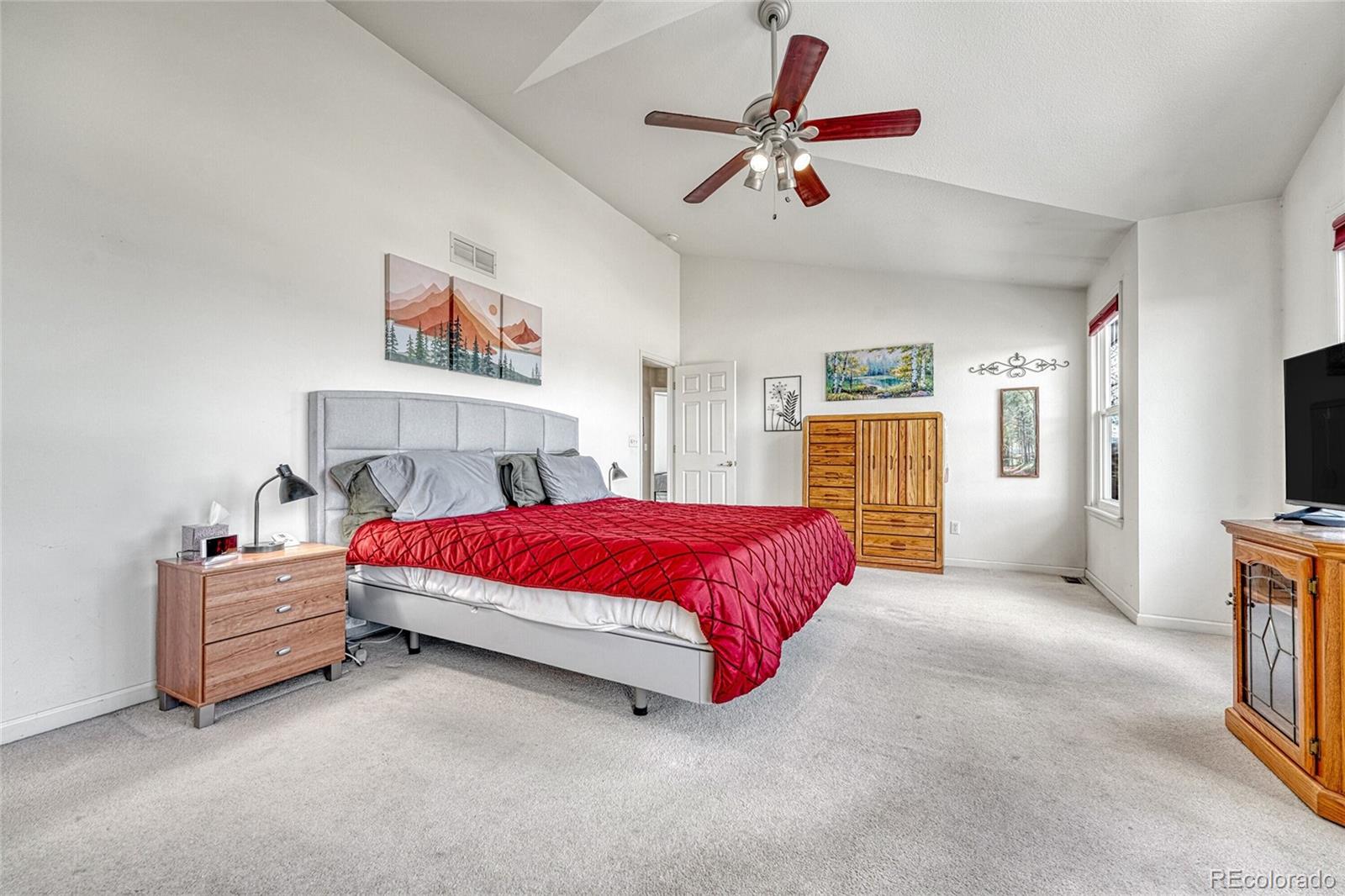 9247 Sugarstone Circle Highlands Ranch, CO 80130 - Photo 19 of 48 a spacious bedroom with a bed and a chandelier