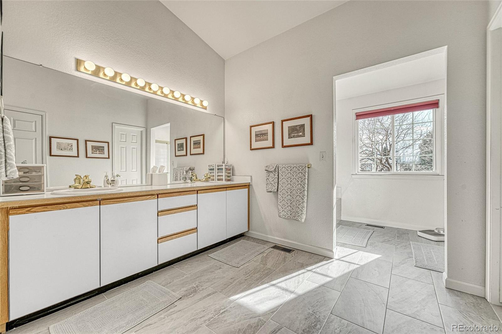 9247 Sugarstone Circle Highlands Ranch, CO 80130 - Photo 20 of 48 a spacious bathroom with a double vanity sink a mirror and a bathtub