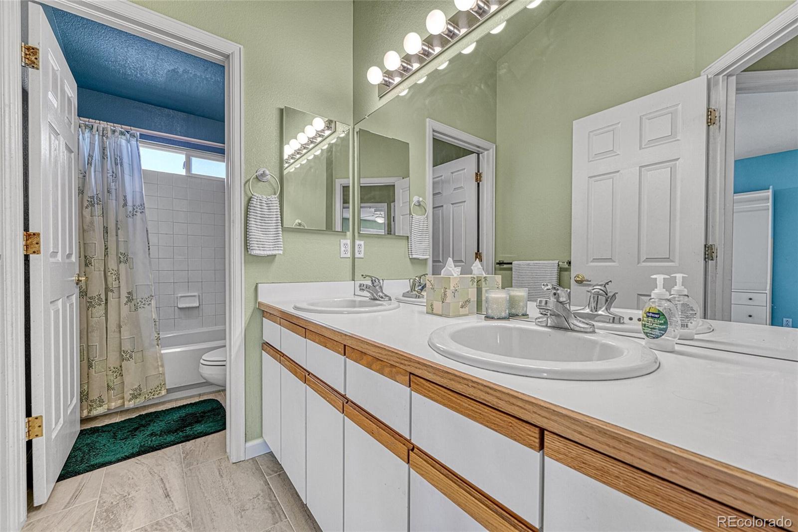 9247 Sugarstone Circle Highlands Ranch, CO 80130 - Photo 26 of 48 a bathroom with a double vanity sink and a mirror