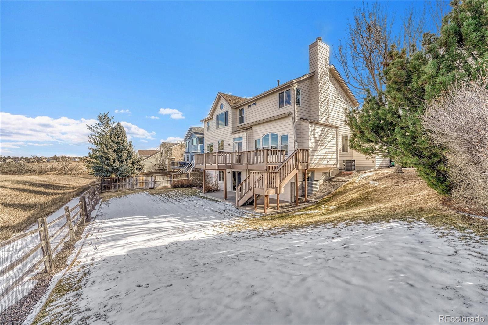 9247 Sugarstone Circle Highlands Ranch, CO 80130 - Photo 37 of 48 a view of a house with large trees and a big yard