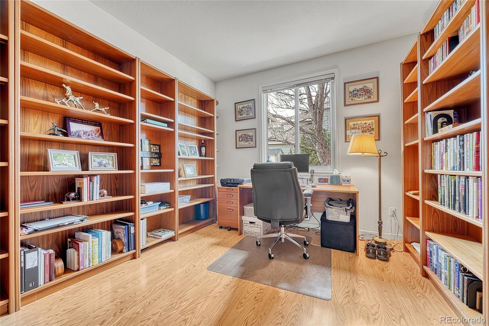 9247 Sugarstone Circle Highlands Ranch, CO 80130 - Photo 6 of 48 a view of a workspace with furniture and a bookshelf