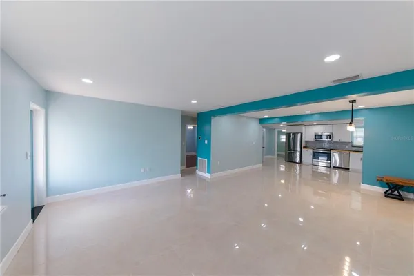 a kitchen with stainless steel appliances a refrigerator a stove a sink a microwave and white cabinets