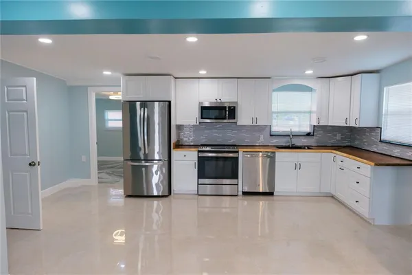 a large kitchen with stainless steel appliances granite countertop a refrigerator sink and stove