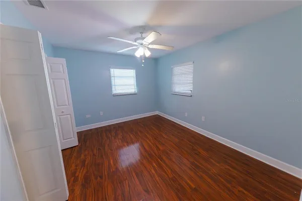 an empty room with wooden floor and closet