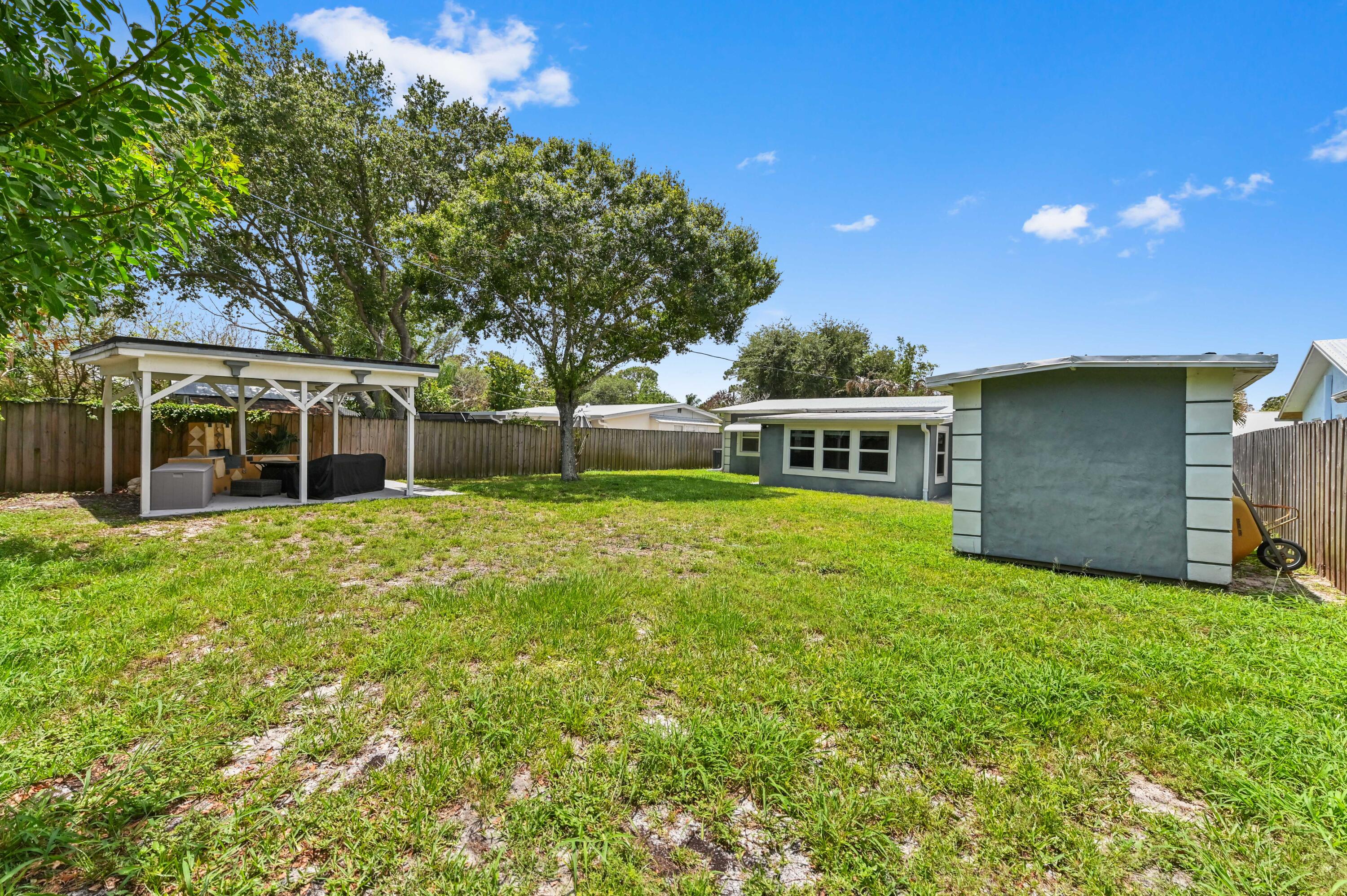 5709 Southeast Indigo Avenue Stuart, FL 34997 - Photo 24 of 26 a front view of a house with garden