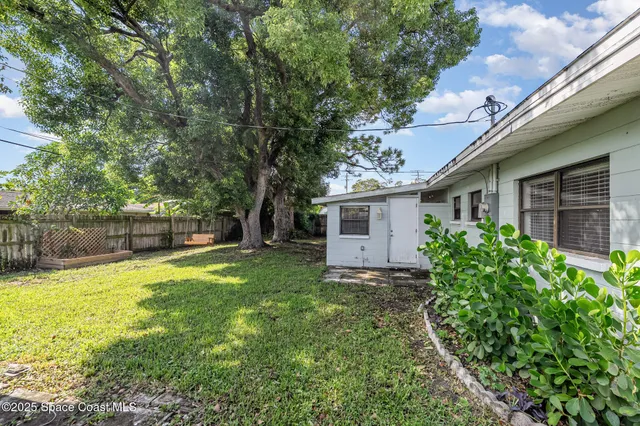 a view of backyard with a garden and trees