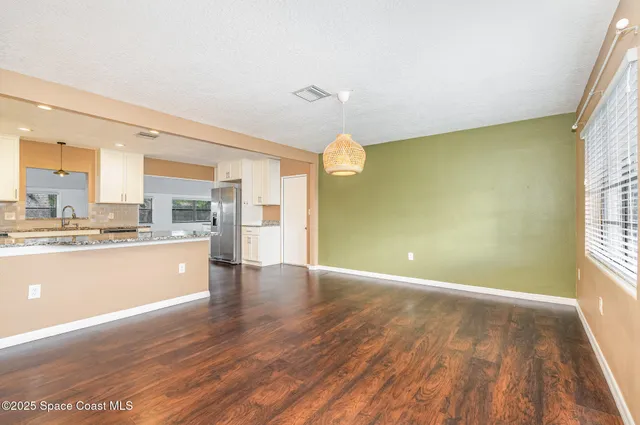 a view of a kitchen with wooden floor and a kitchen
