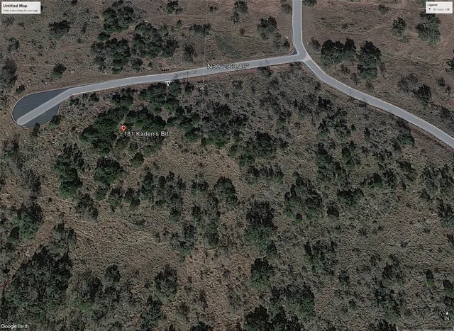 a view of a dry yard with wooden fence