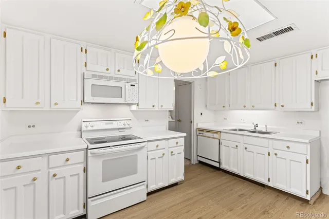 a kitchen with white cabinets and sink