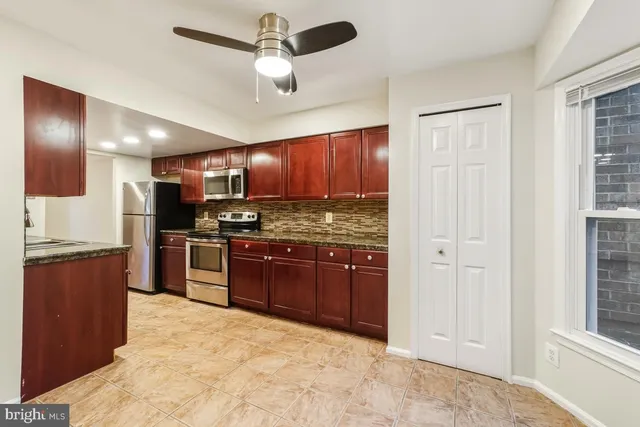 a kitchen with stainless steel appliances granite countertop a refrigerator and a stove top oven