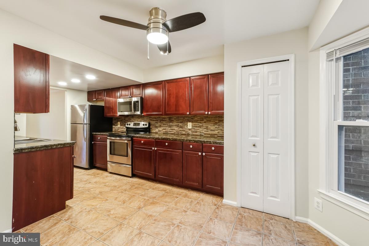 9040 Armendown Drive Springfield, VA 22152 - Photo 12 of 30 a kitchen with stainless steel appliances granite countertop a stove sink and cabinets