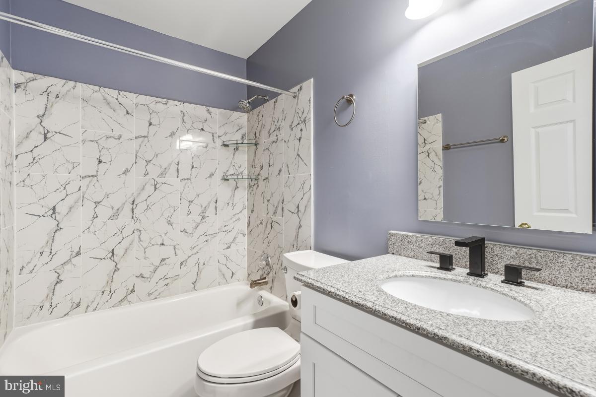 9040 Armendown Drive Springfield, VA 22152 - Photo 17 of 30 a bathroom with a granite countertop sink toilet bathtub and shower
