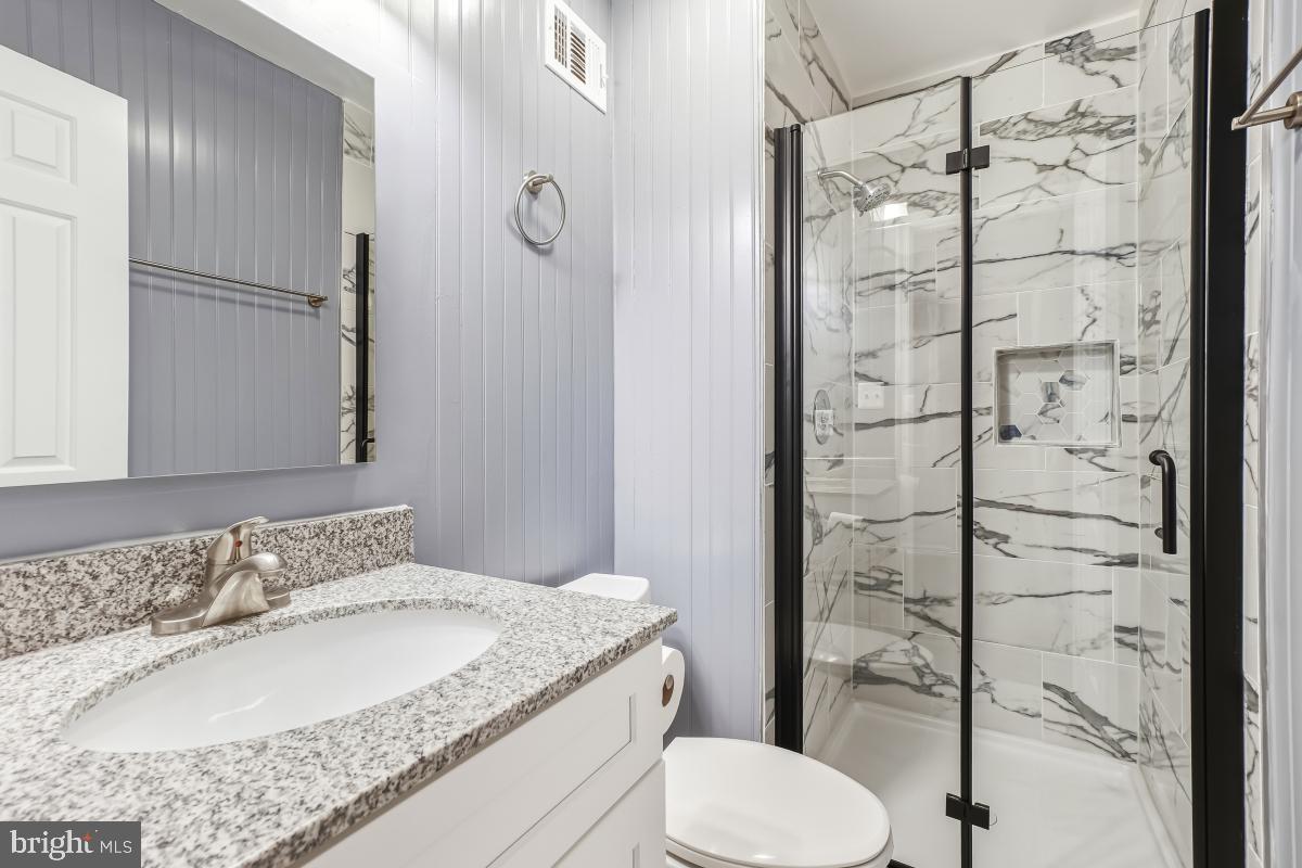 9040 Armendown Drive Springfield, VA 22152 - Photo 19 of 30 a bathroom with a granite countertop sink toilet and shower