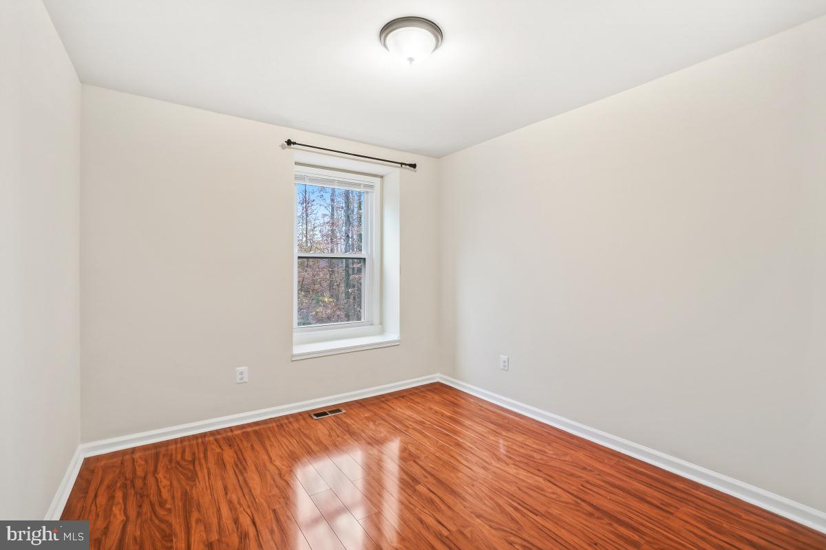 9040 Armendown Drive Springfield, VA 22152 - Photo 21 of 30 an empty room with wooden floor and windows