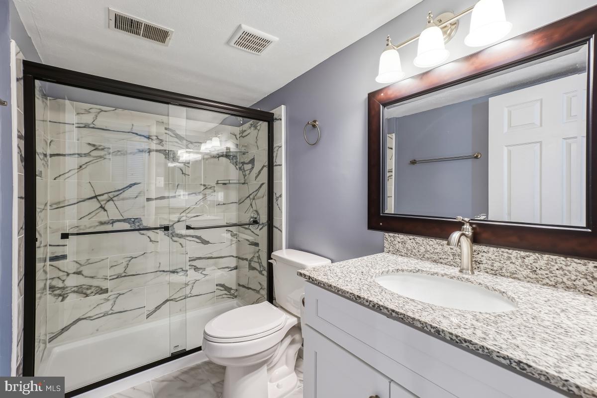 9040 Armendown Drive Springfield, VA 22152 - Photo 26 of 30 a bathroom with a granite countertop sink toilet and shower