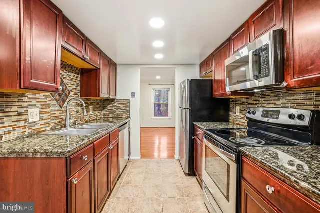 a kitchen with granite countertop stainless steel appliances and wooden cabinets