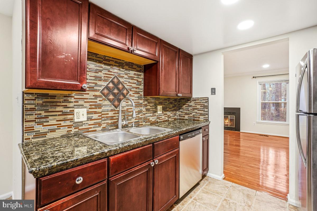 9040 Armendown Drive Springfield, VA 22152 - Photo 10 of 30 a kitchen with granite countertop stainless steel appliances and wooden cabinets