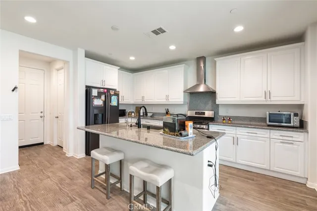 a kitchen with refrigerator a sink and chairs