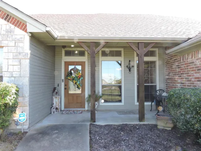 a view of a porch with a table and chairs and potted plants