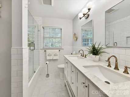 a bathroom with a double vanity sink mirror and next to a window